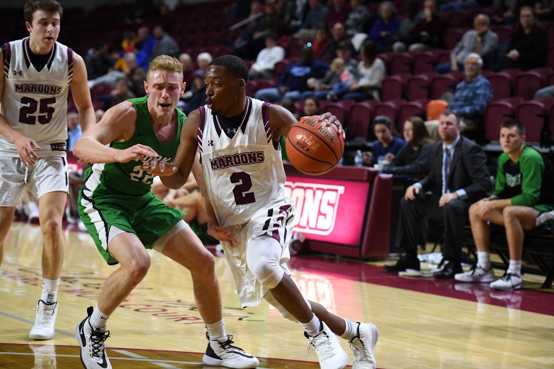action photo to RC basketball player Caleb Jordan dribbling past a defender