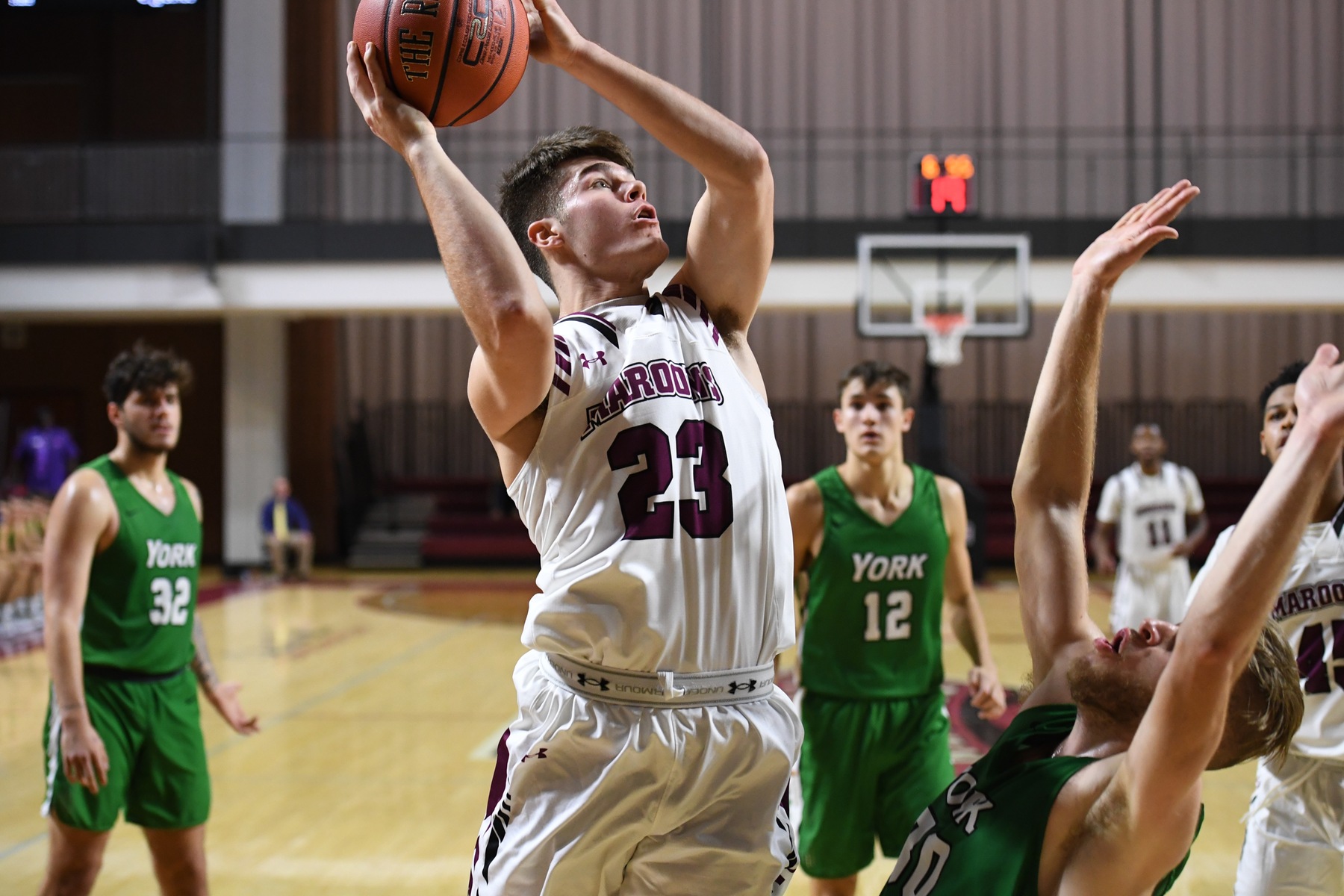 action photo of RC basketball player Kasey Draper scoring over a defender