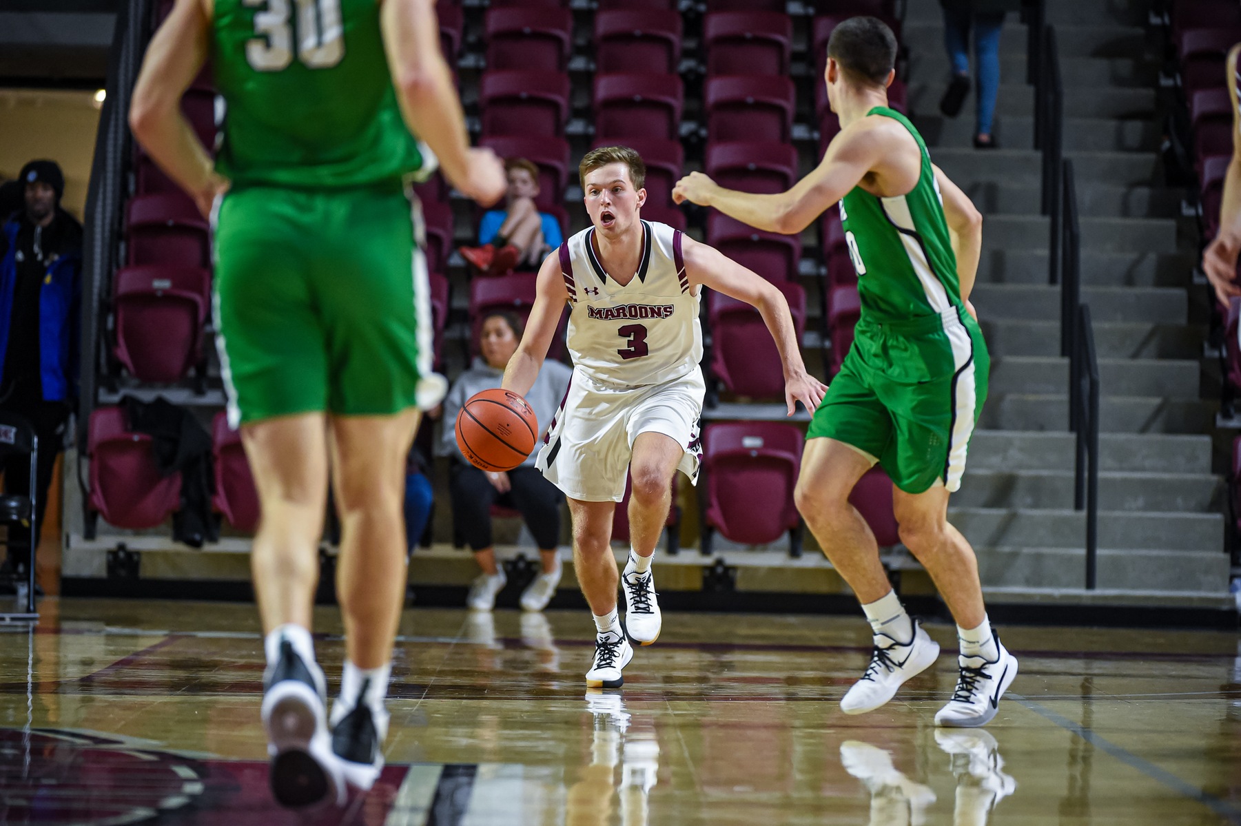 action photo of RC basketball player Dillon Thomas bringing the ball up the court