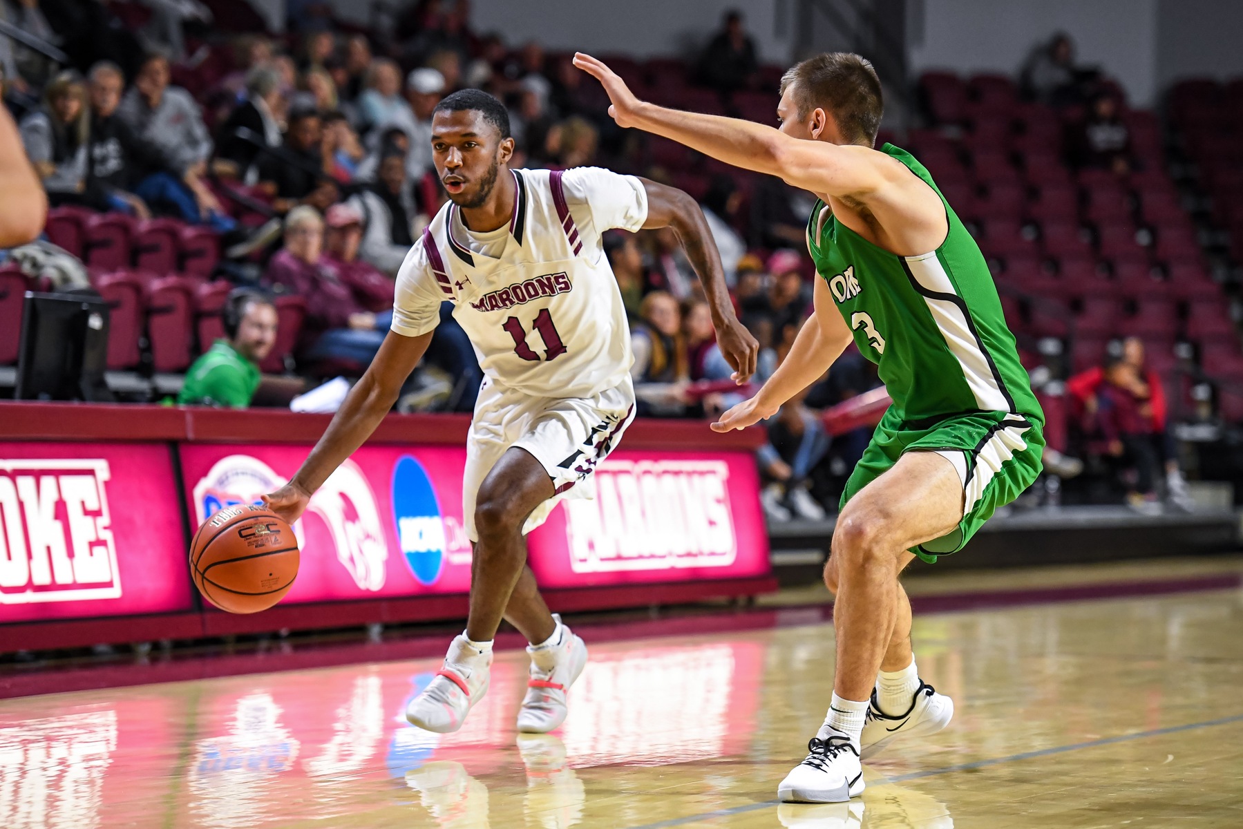 action photo of Roanoke College basketball player Nick Price dribbling past defender