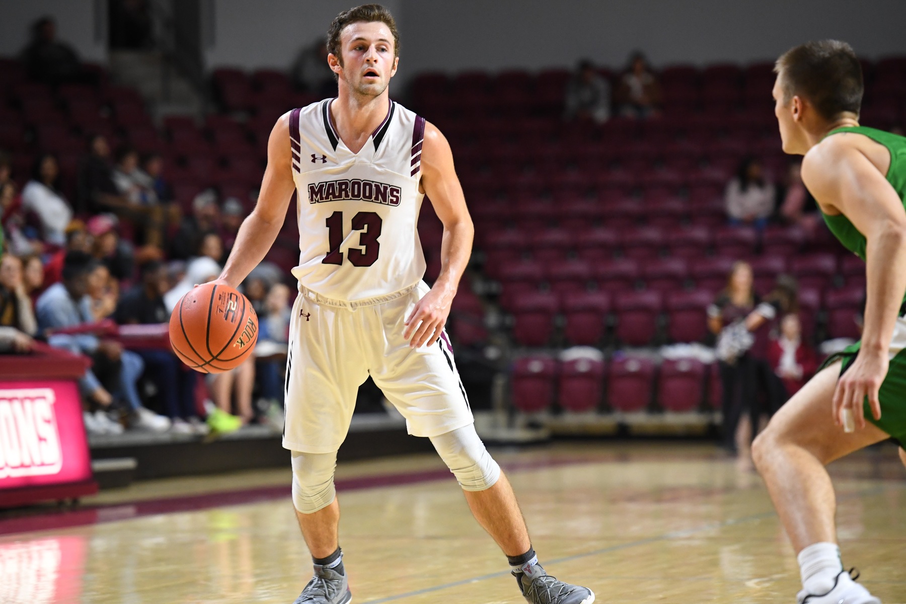 action photo of RC basketball player Tripp Greene dribbling against a defender