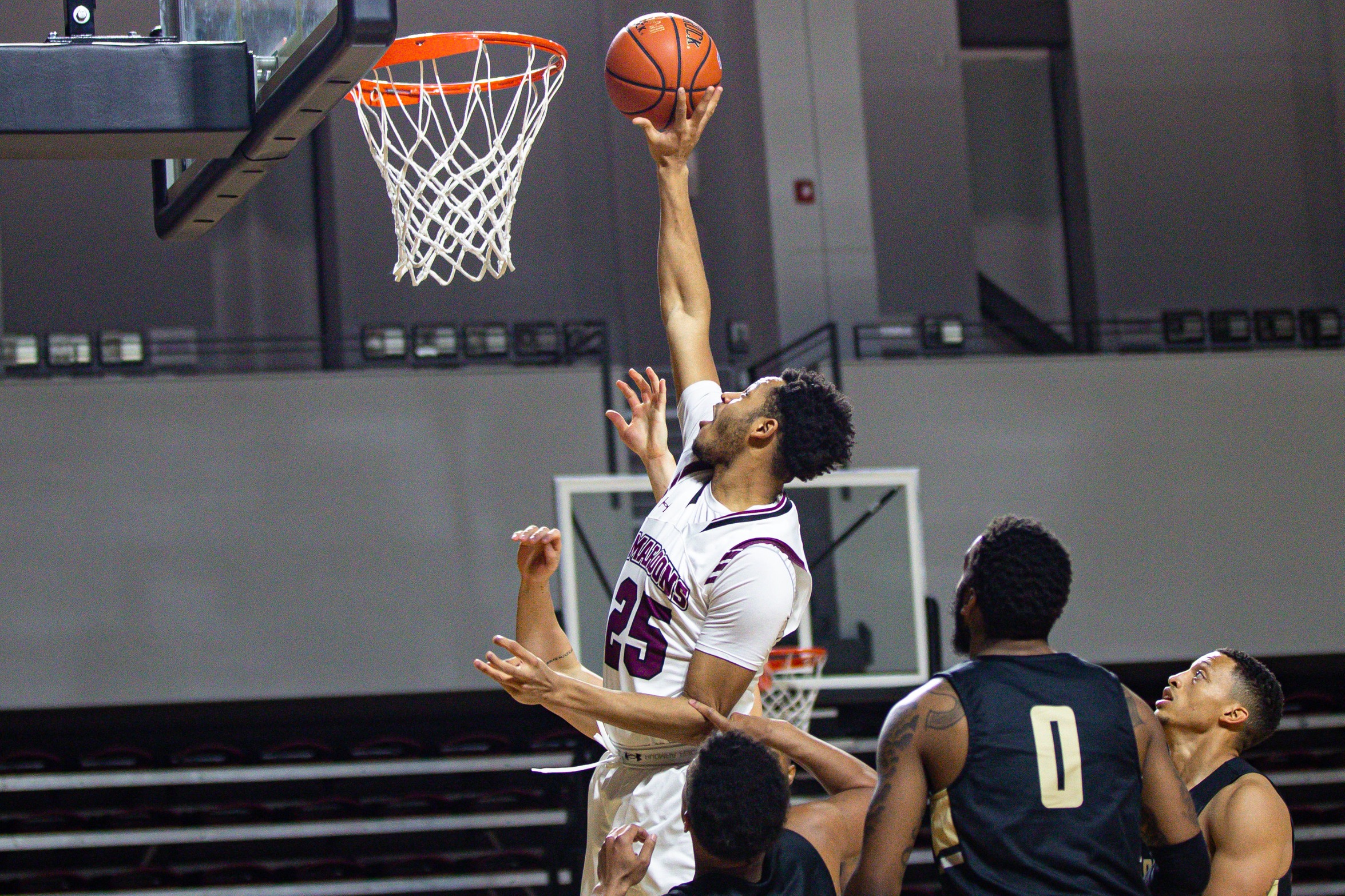action photo of RC basketball player Ethan Rohan at the rim