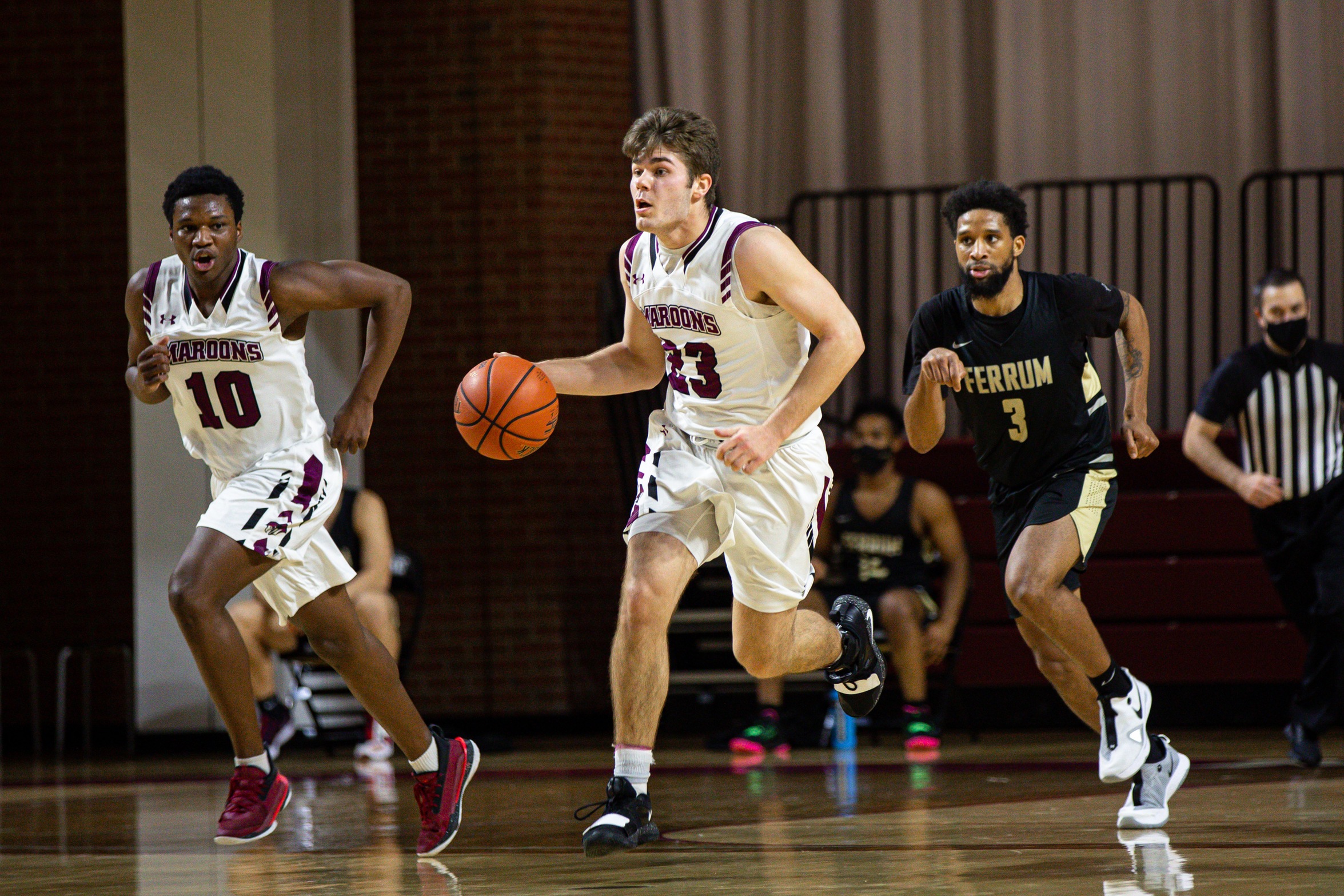 action photo of RC basketball player Kasey Draper leading the fast break