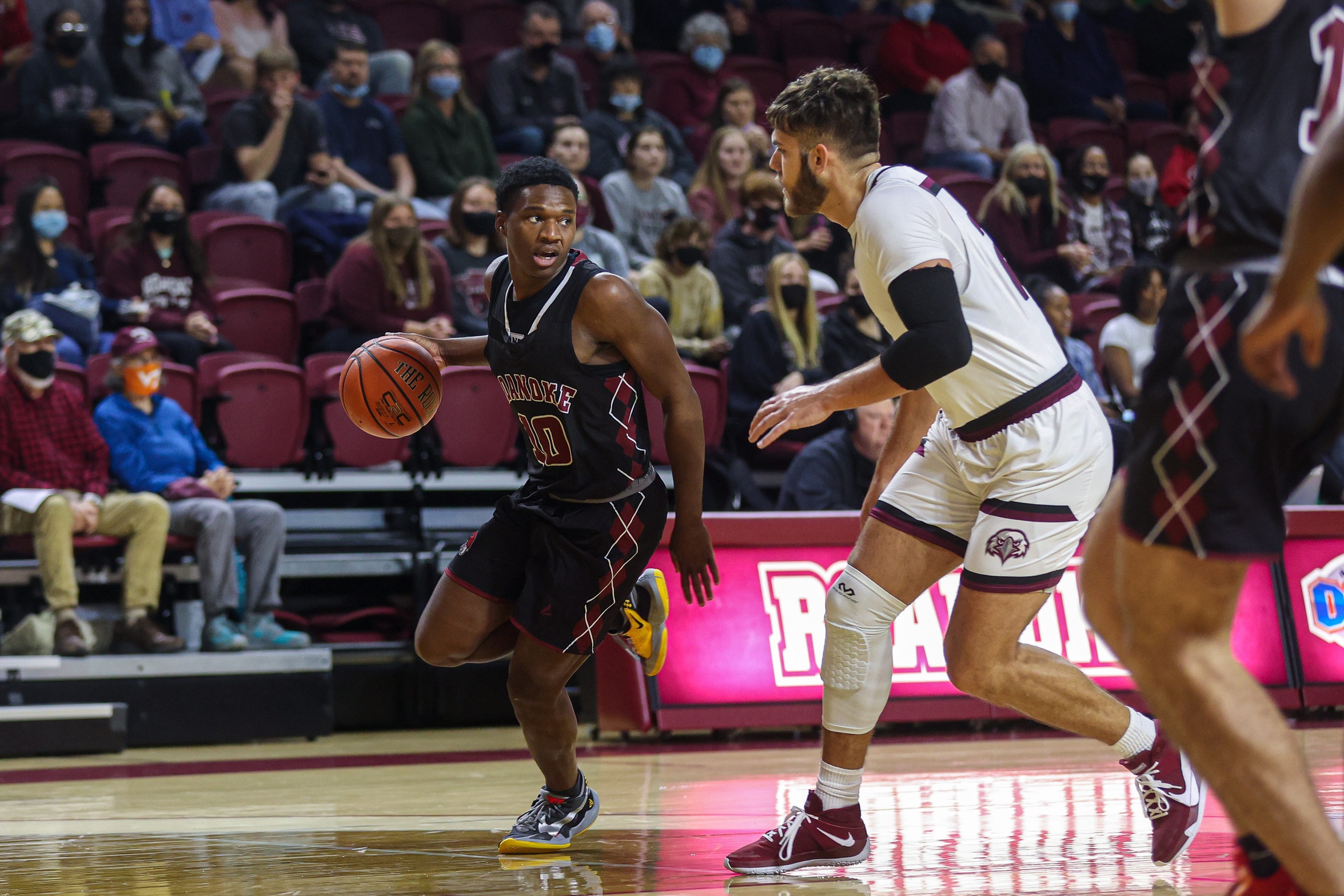 action photo of RC men's basketball player Efosa U-Edosomwan dribbling past a defender