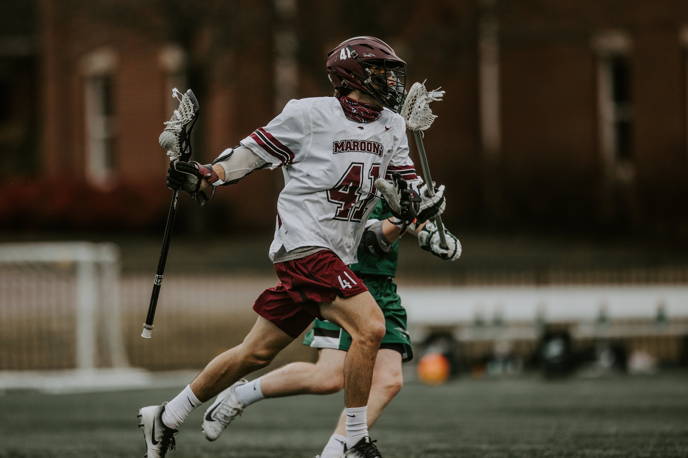 action photo of RC lacrosse player Luke Kammerman carrying the ball