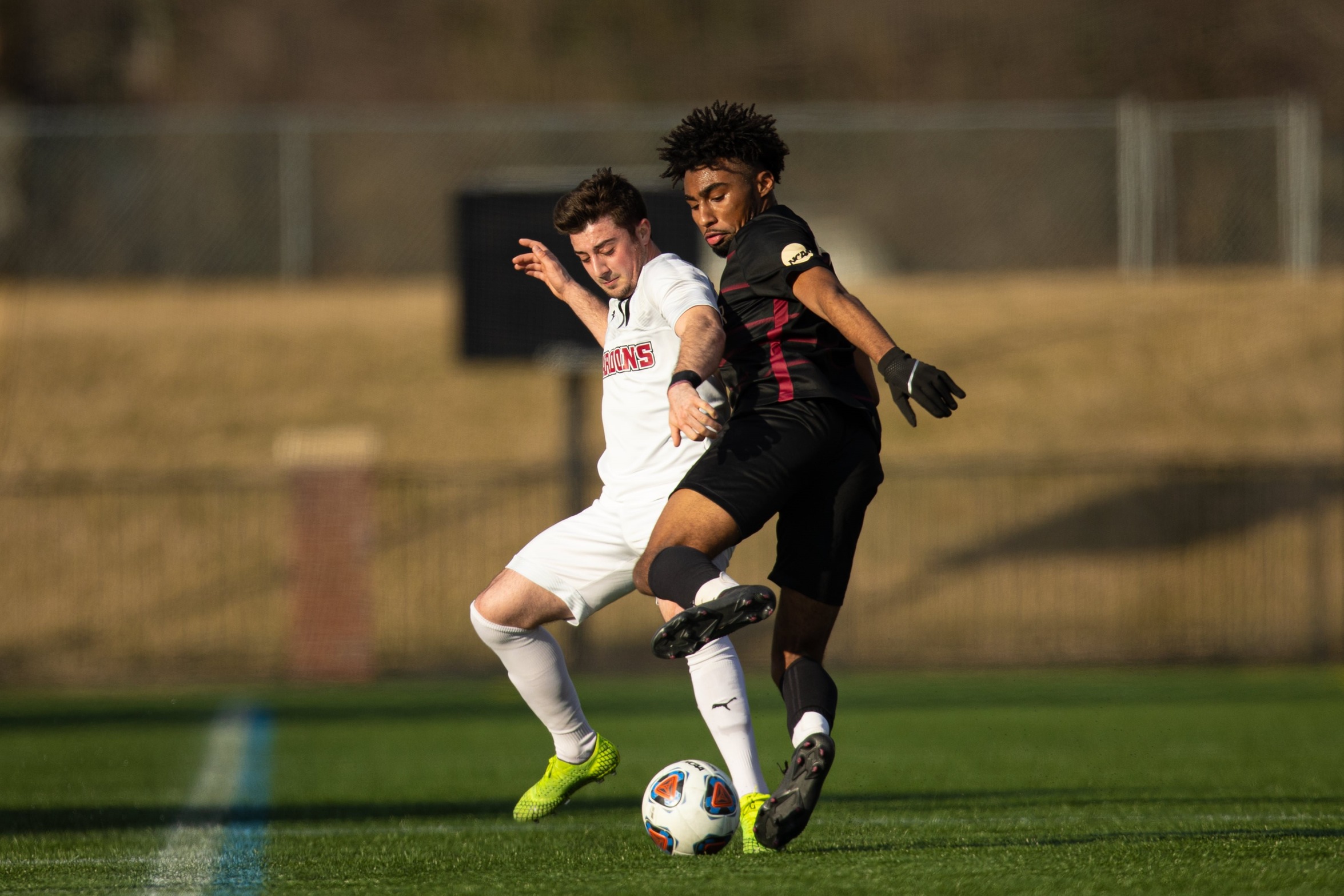 action photo of RC soccer player battling a Bridgewater player for the ball