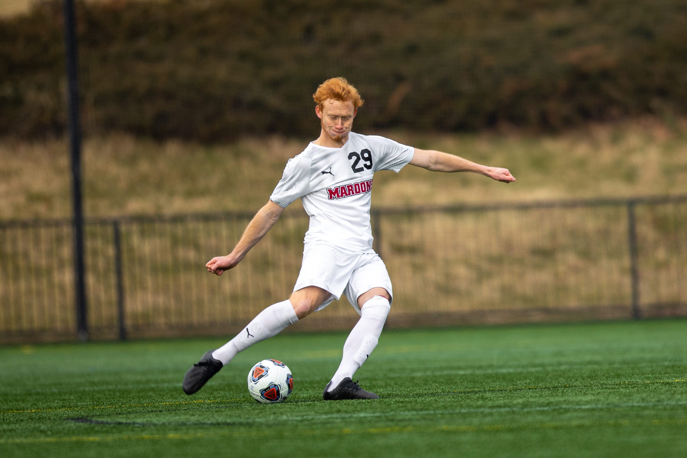 action photo of RC soccer player Joe Carman kicking