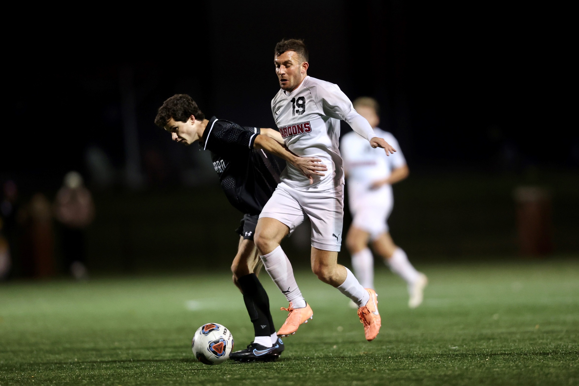 action photo of RC men's soccer player Liam Camilleri battling for a ball