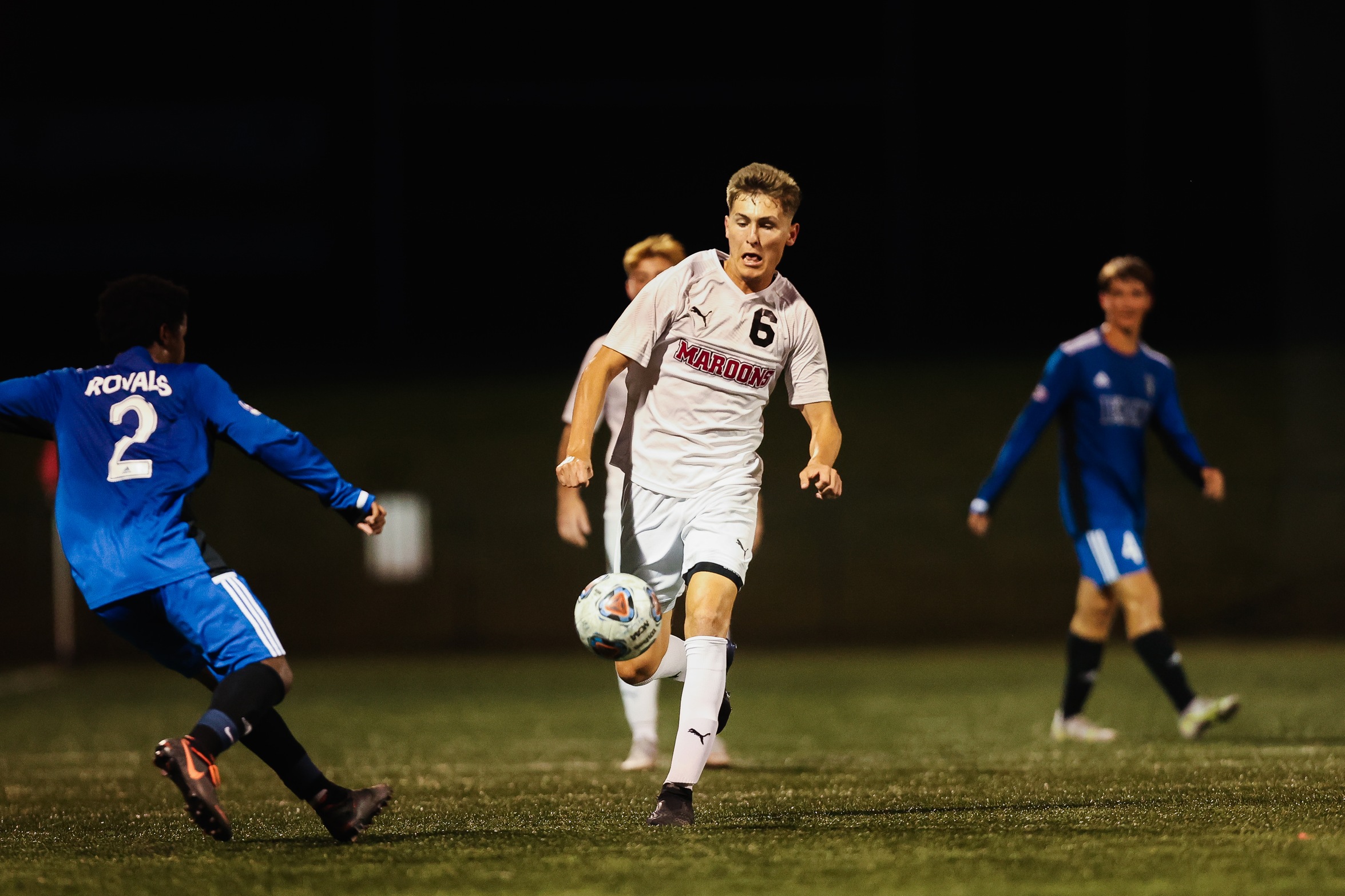 action photo of RC men's soccer player Dylan Berk going after a ball