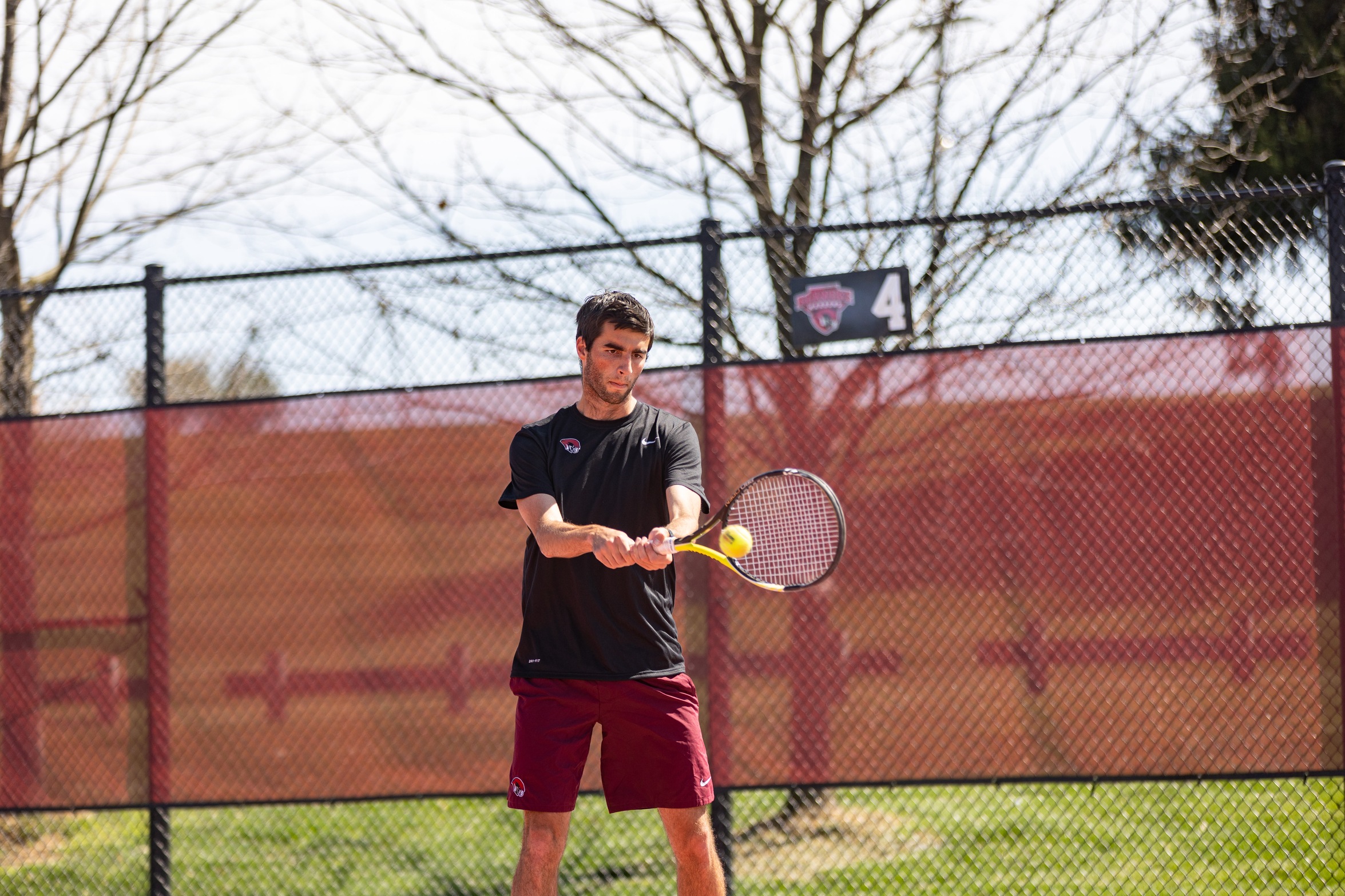 action shot of an RC men's tennis player hitting a backhand