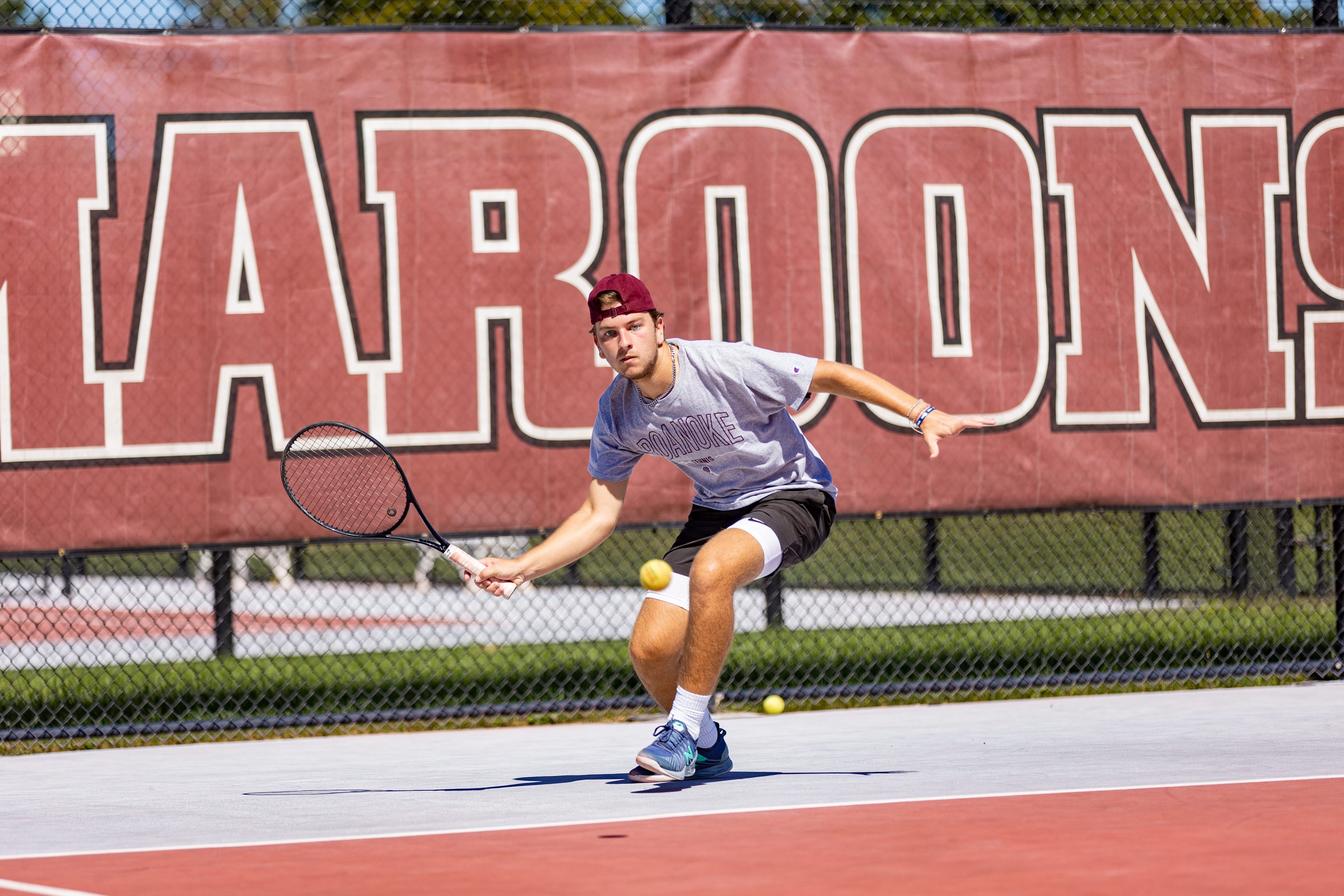 action photo of RC men's tennis player hitting a drop shot