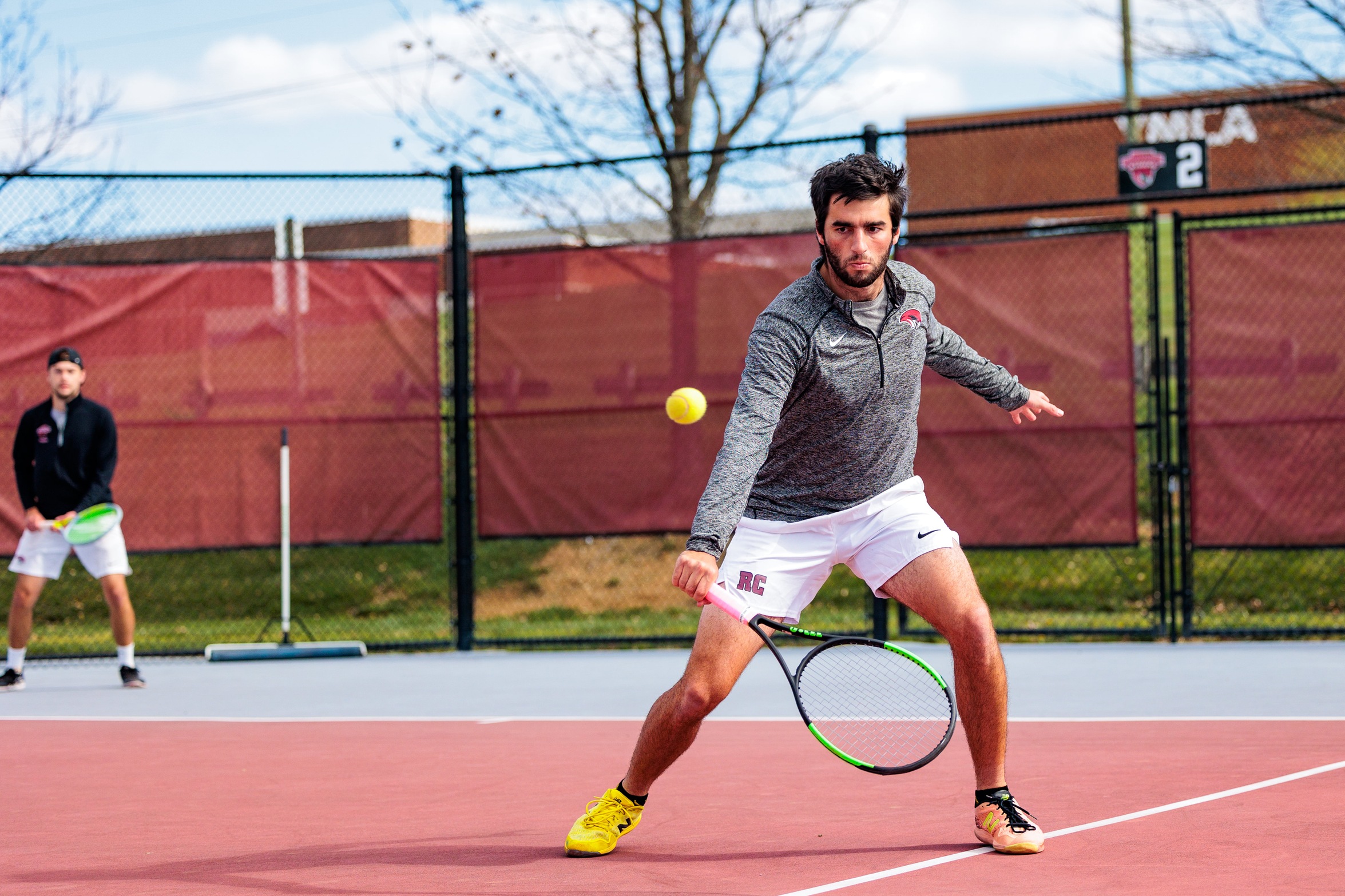 action photo of RC men's tennis player Zach Kriebel backhand at the net 