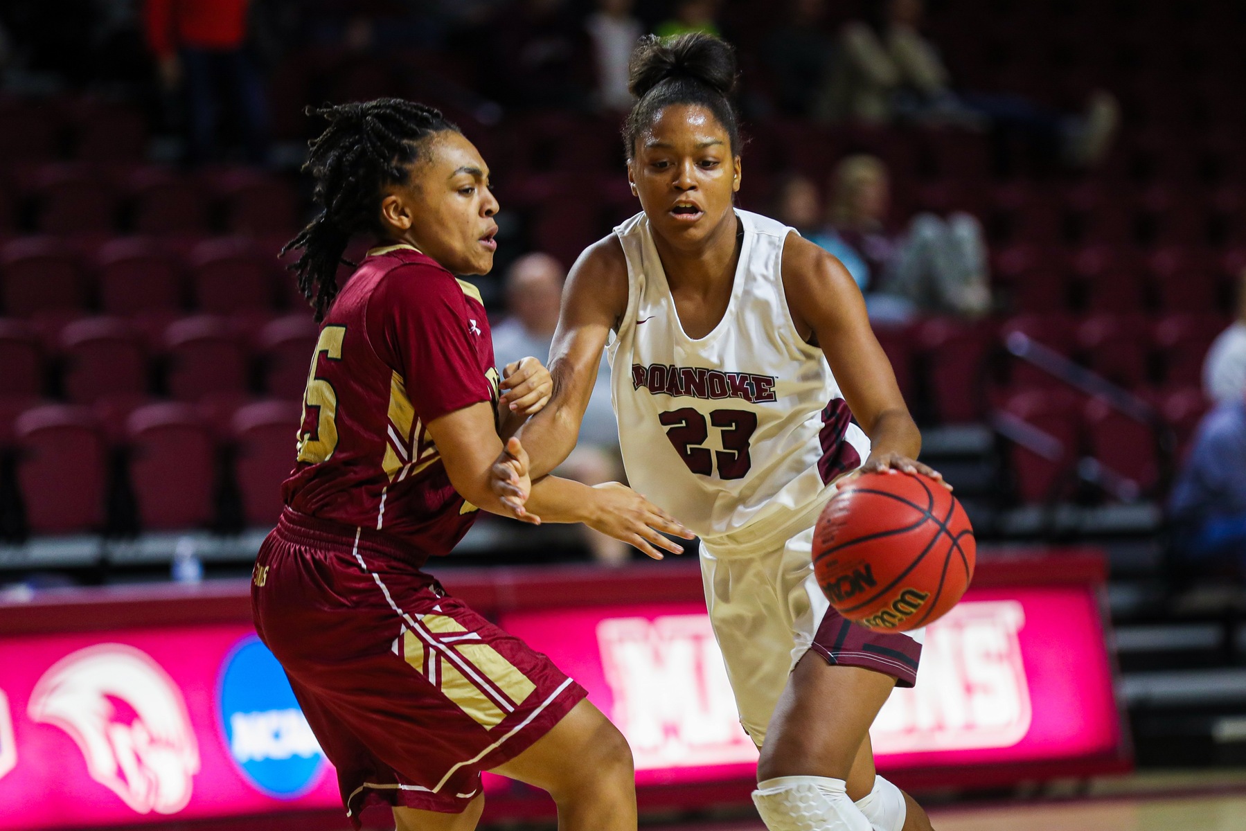 action photo of RC basketball player Ayanna Scarborough dribbling against a defender