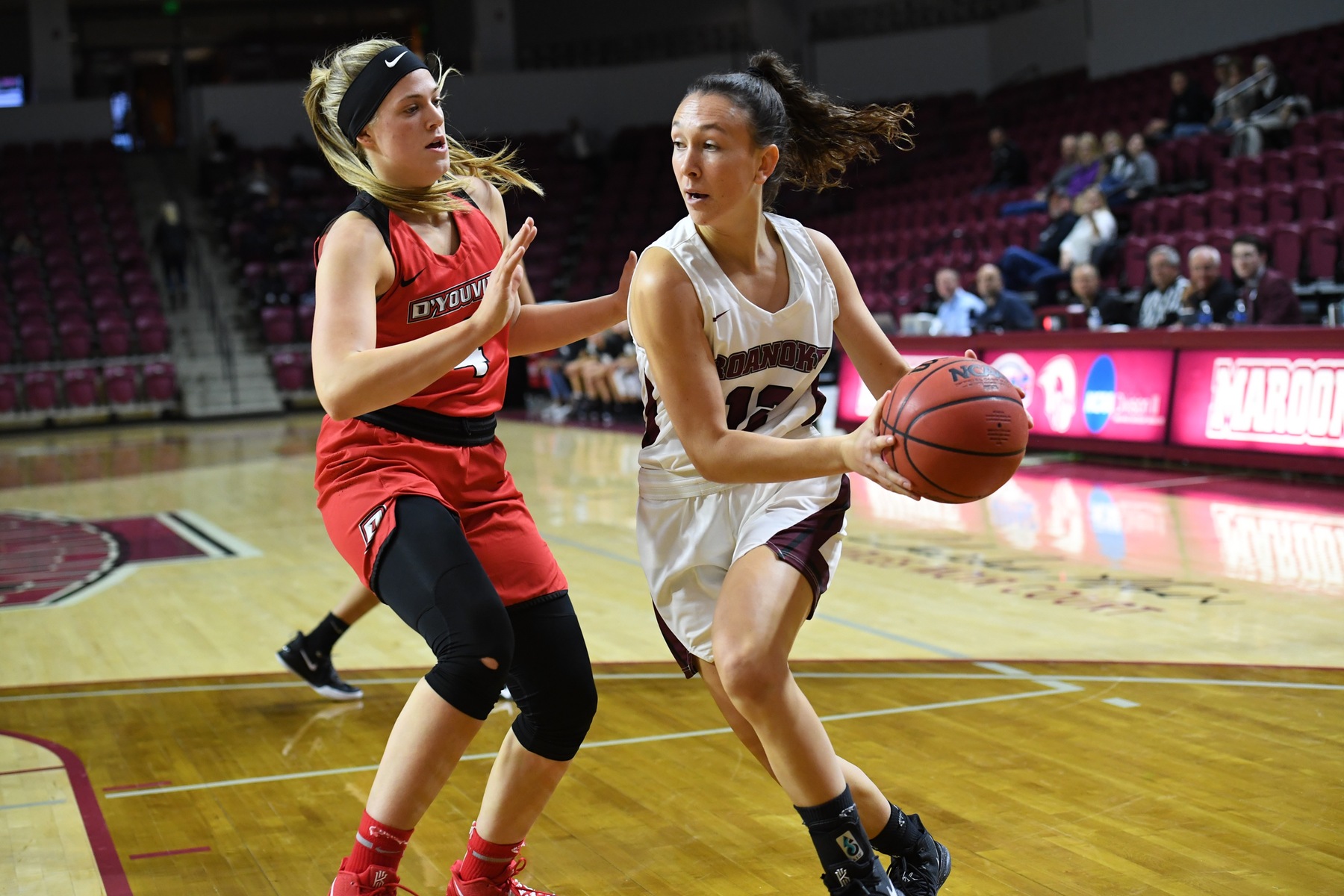 action photo of RC basketball player Kristina Harrel driving to the basket