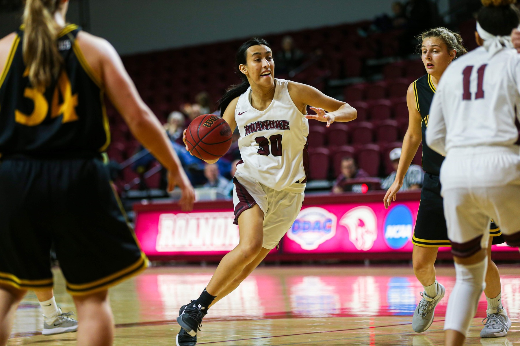 action photo of RC basketball player Renee Alquiza driving to the basket