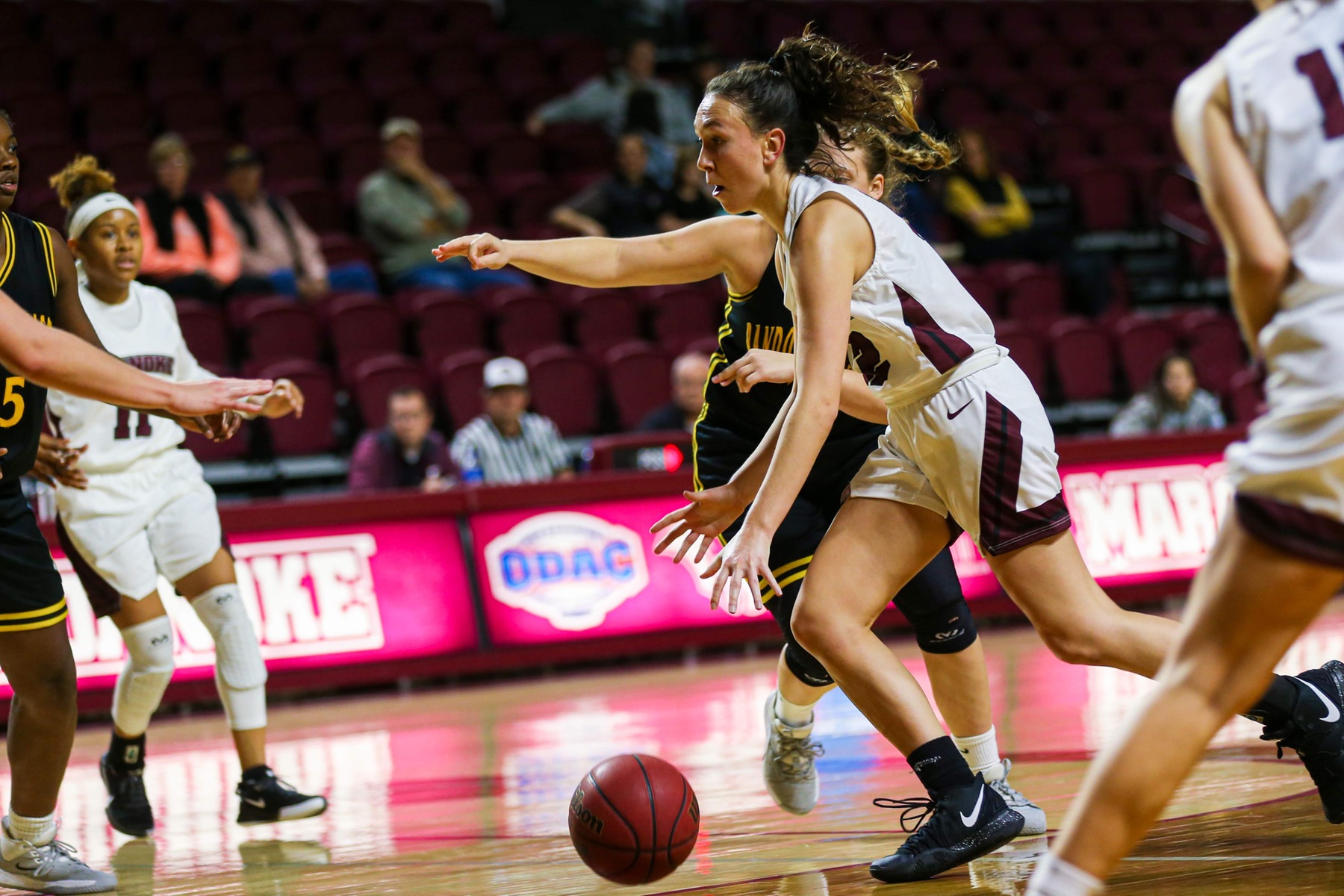 action photo of RC basketball player Kristina Harrel driving to the basket.