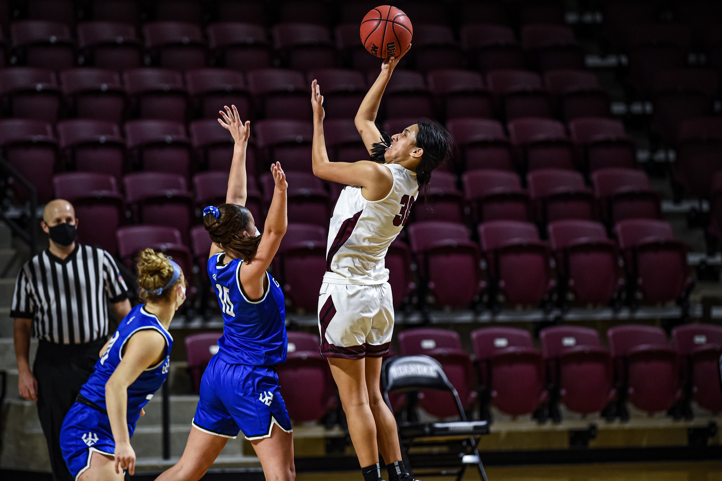action photo of RC basketball player Renee Alquiza shooting over a defender