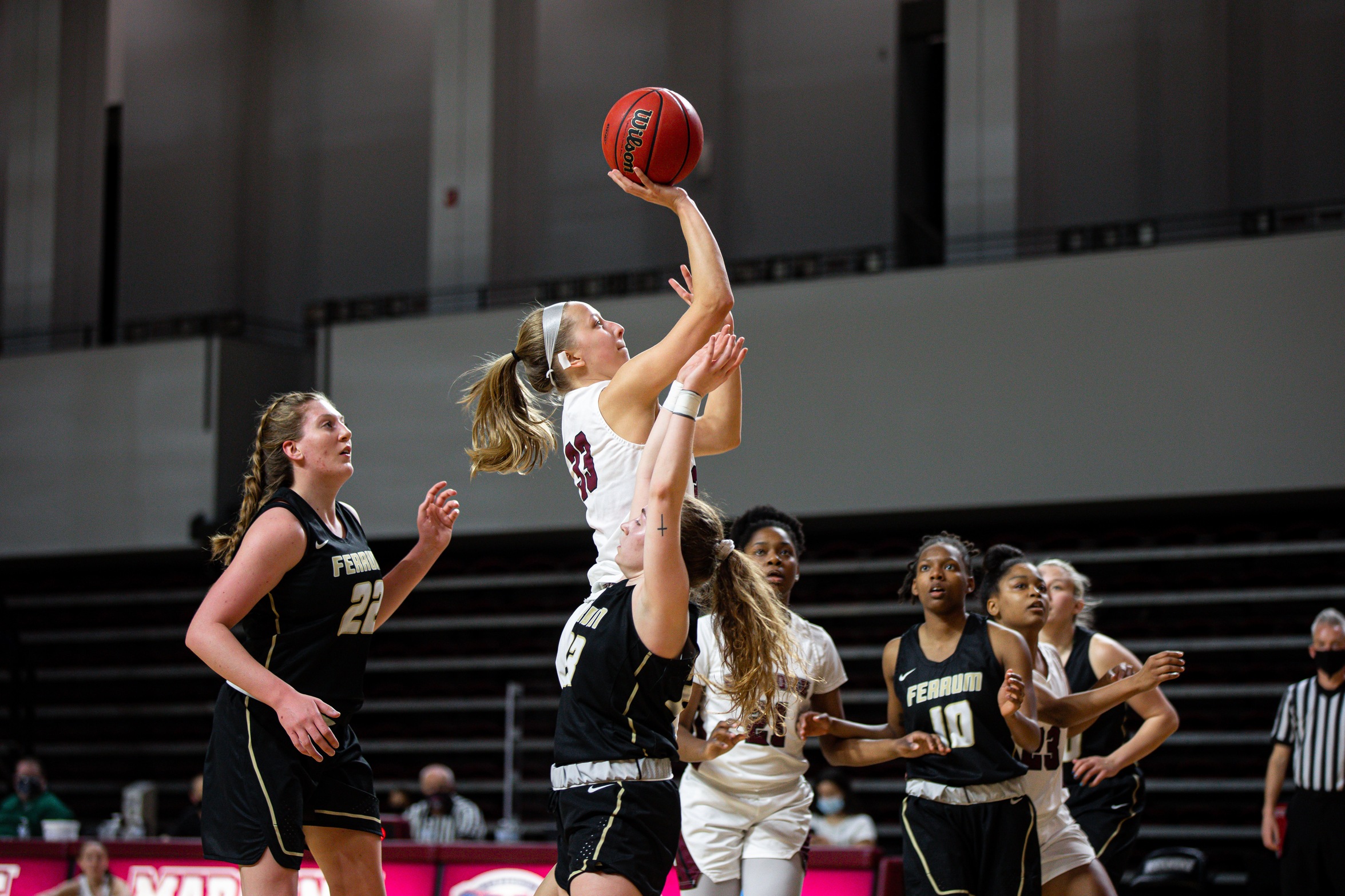 action photo of RC basketball player Rose Sande shooting over a defender