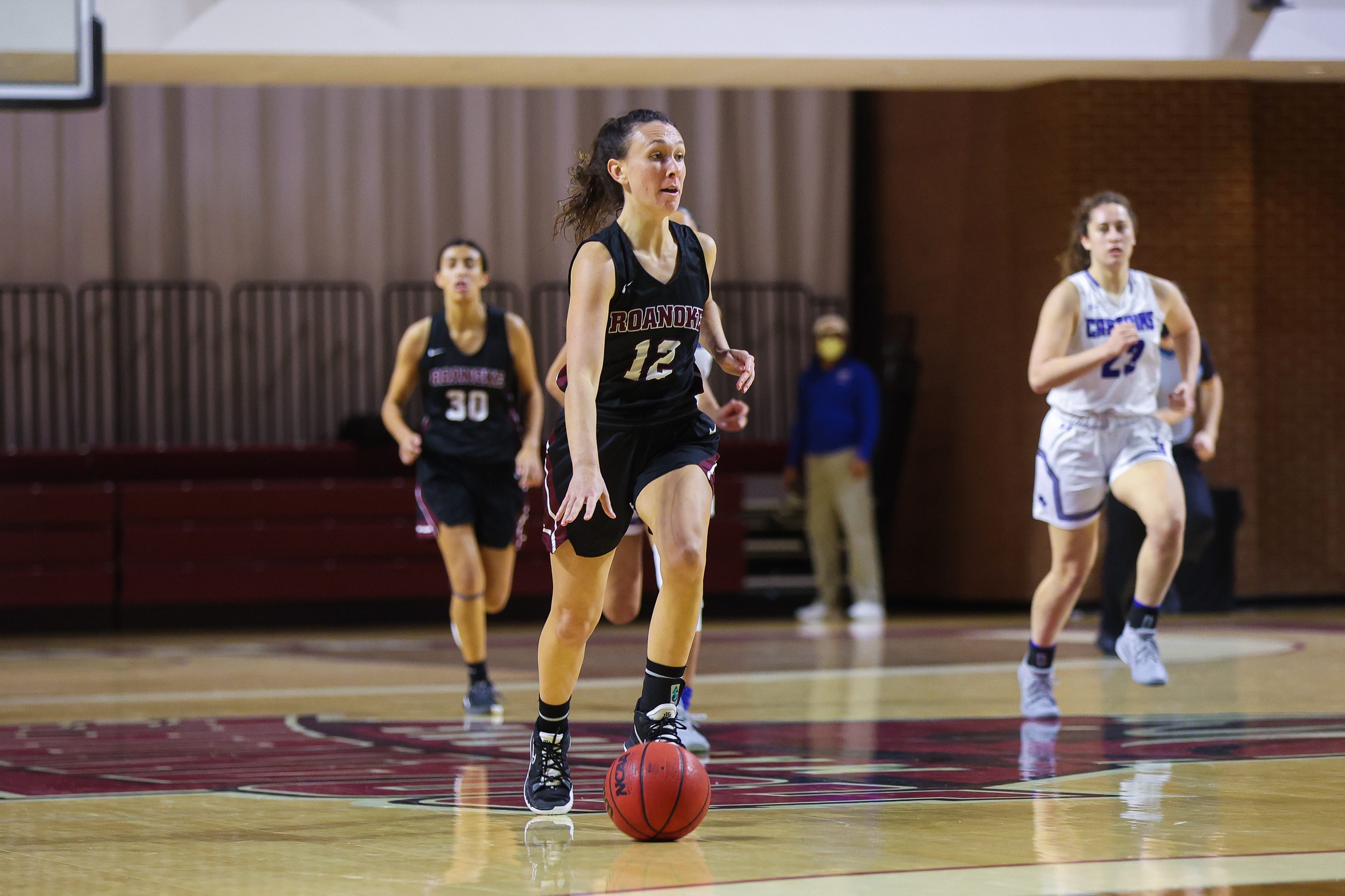action photo of RC WBB Kristina Harrel dribbling up the court