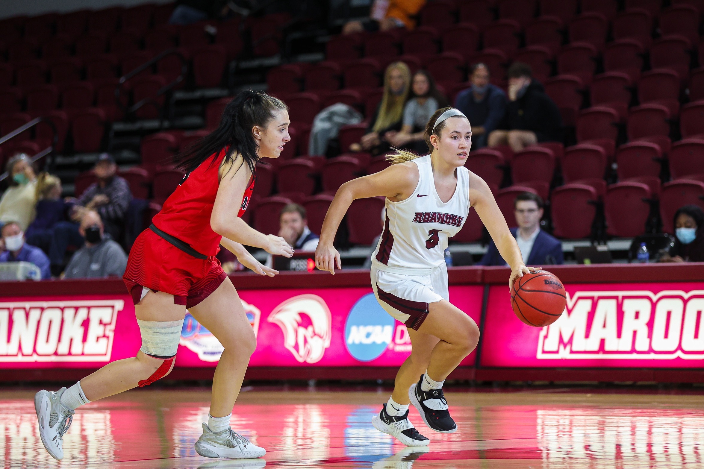 action photo of RC women's basketball player Sayre Brandstatter dribbling past a defender