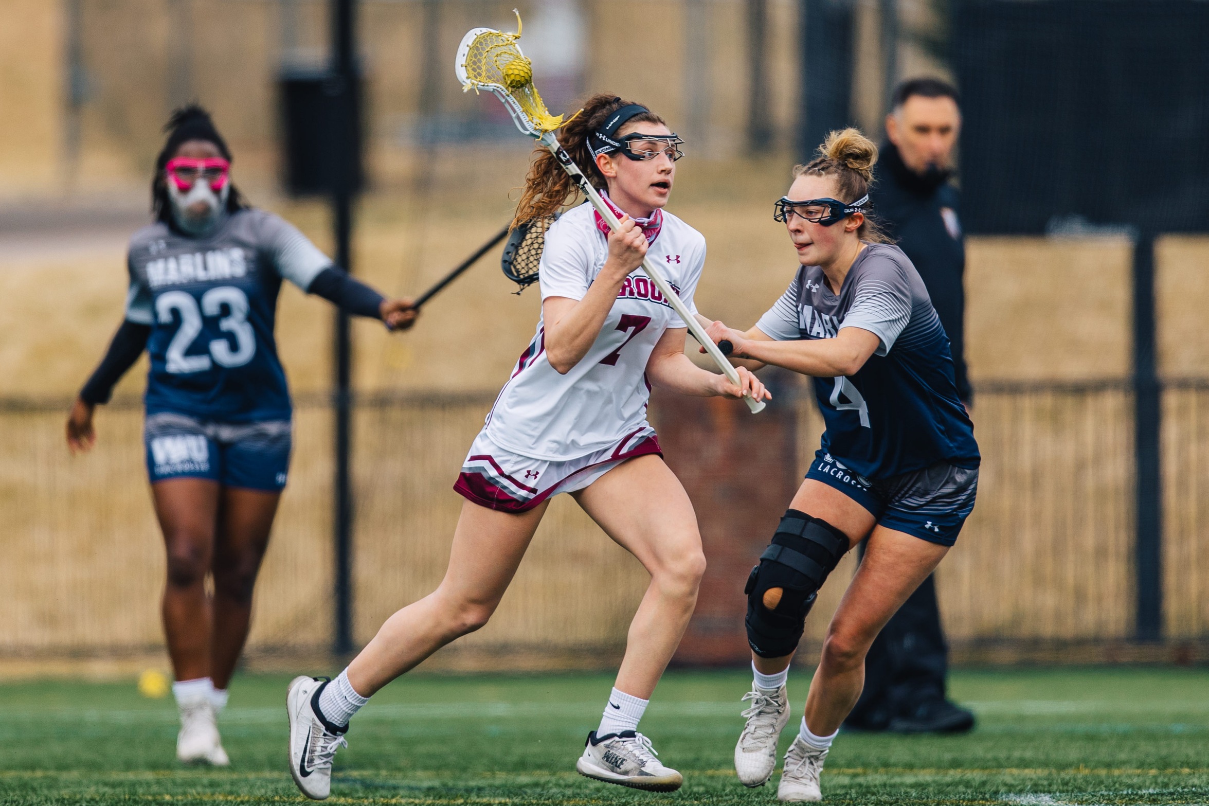 action photo of RC lacrosse player Lilly Blair taking on a defender