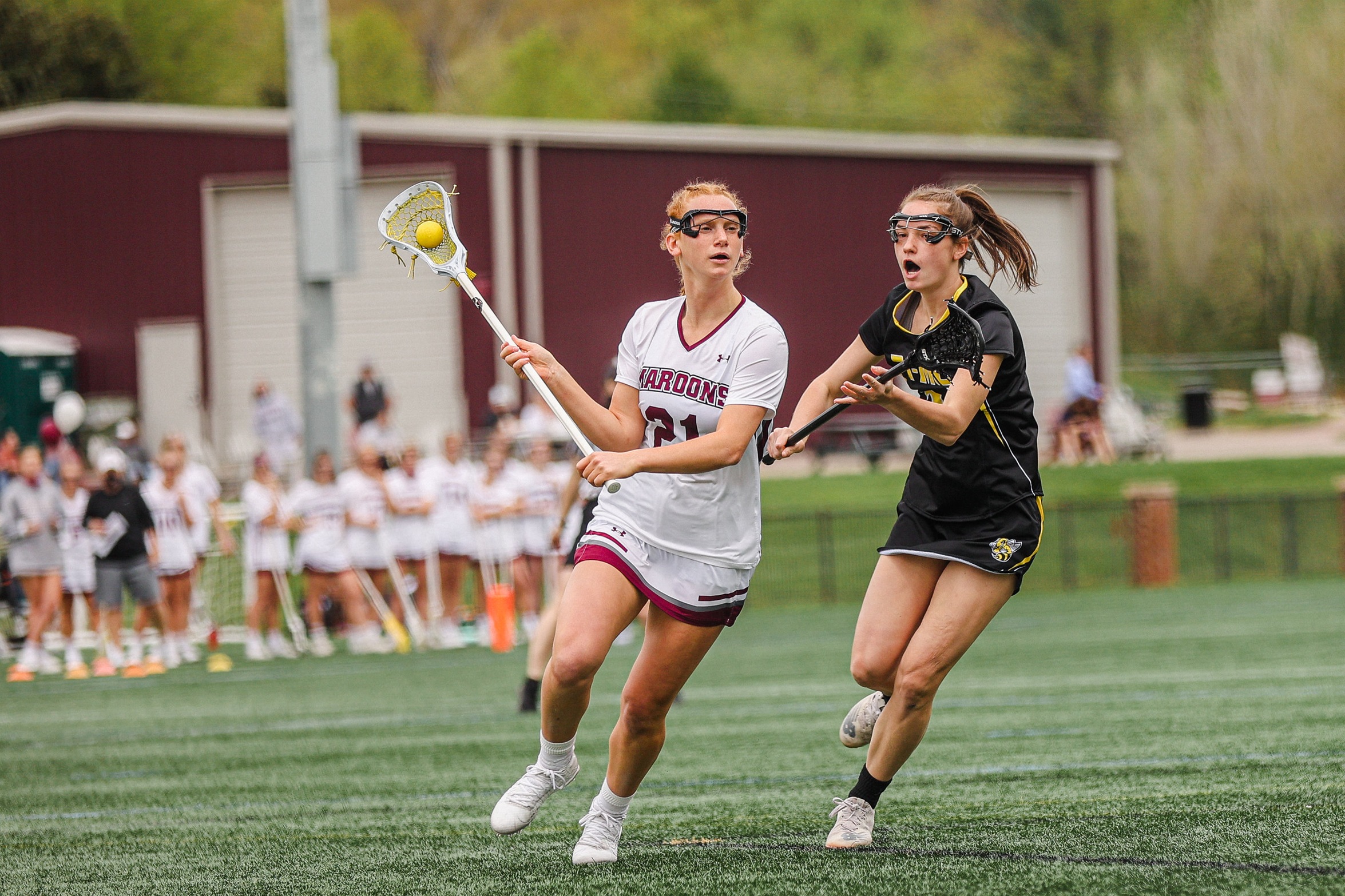 action photo of RC lacrosse player Emerson Foster going past a defender