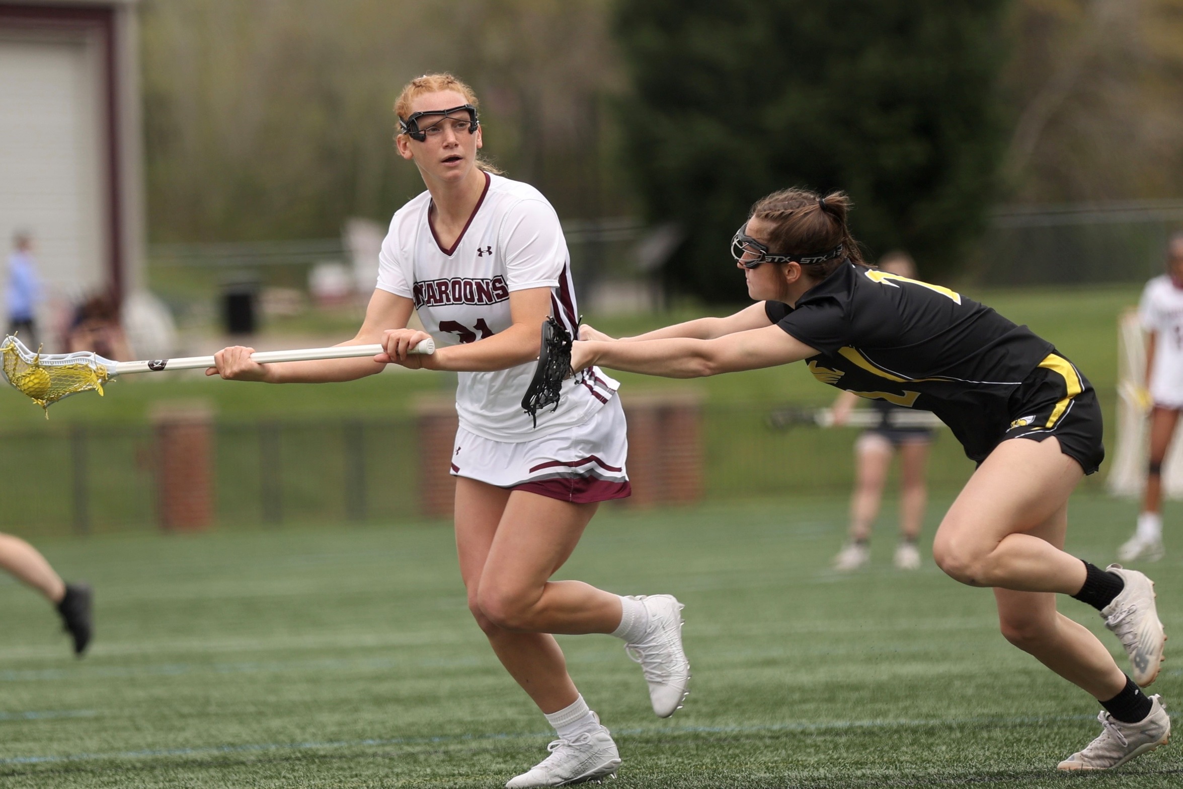 action photo of RC lacrosse player Emerson Foster against a defender