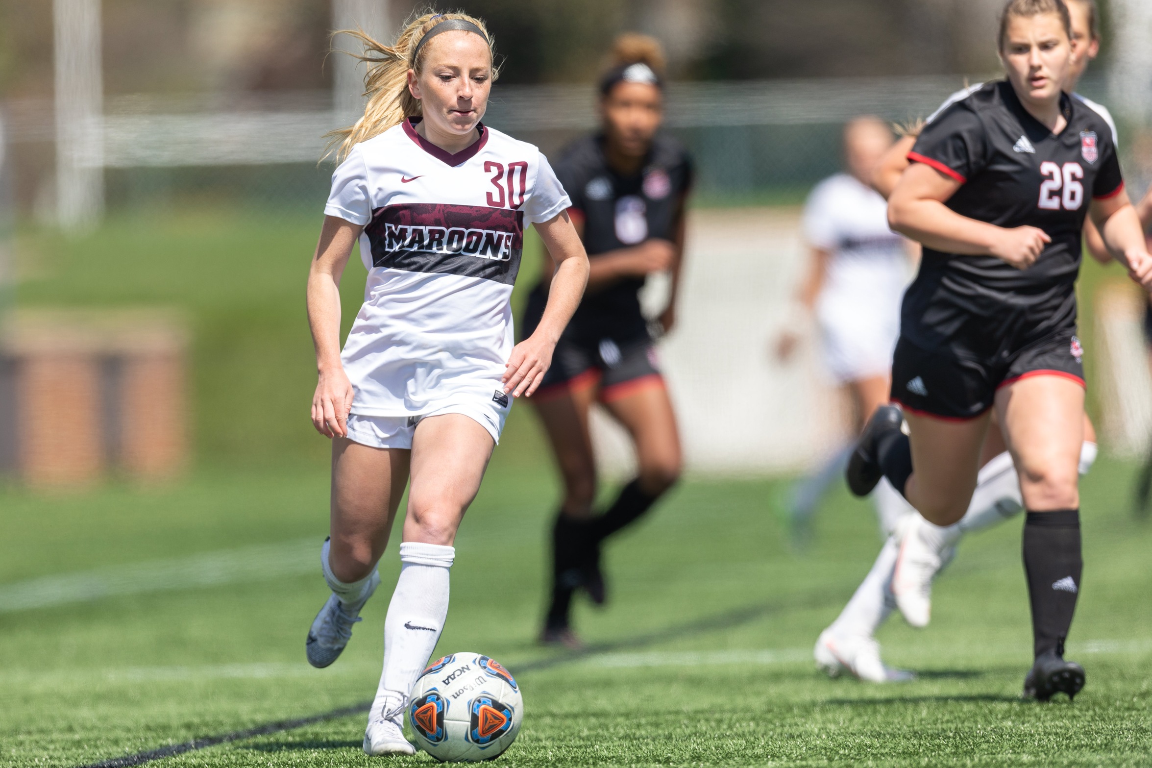 action photo of RC soccer player Morgan O'Neill dribbling to goal