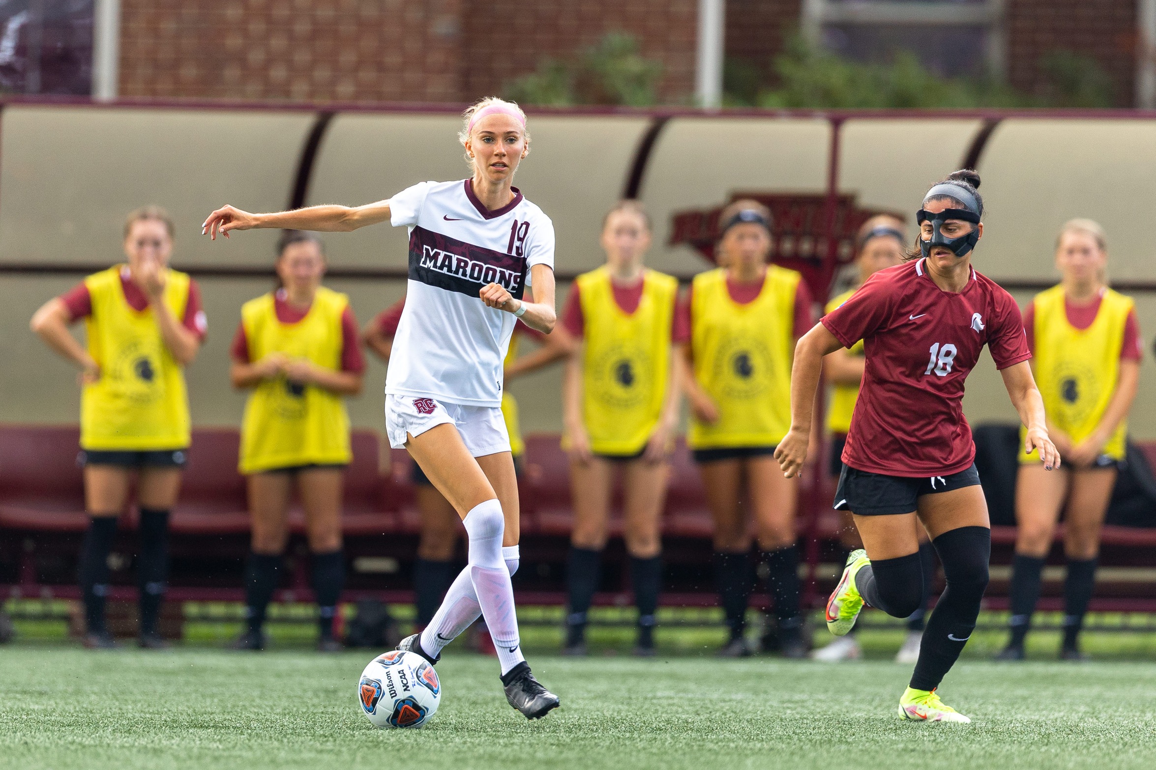 action photo of RC women's soccer player Mia Clary dribbling past a defender