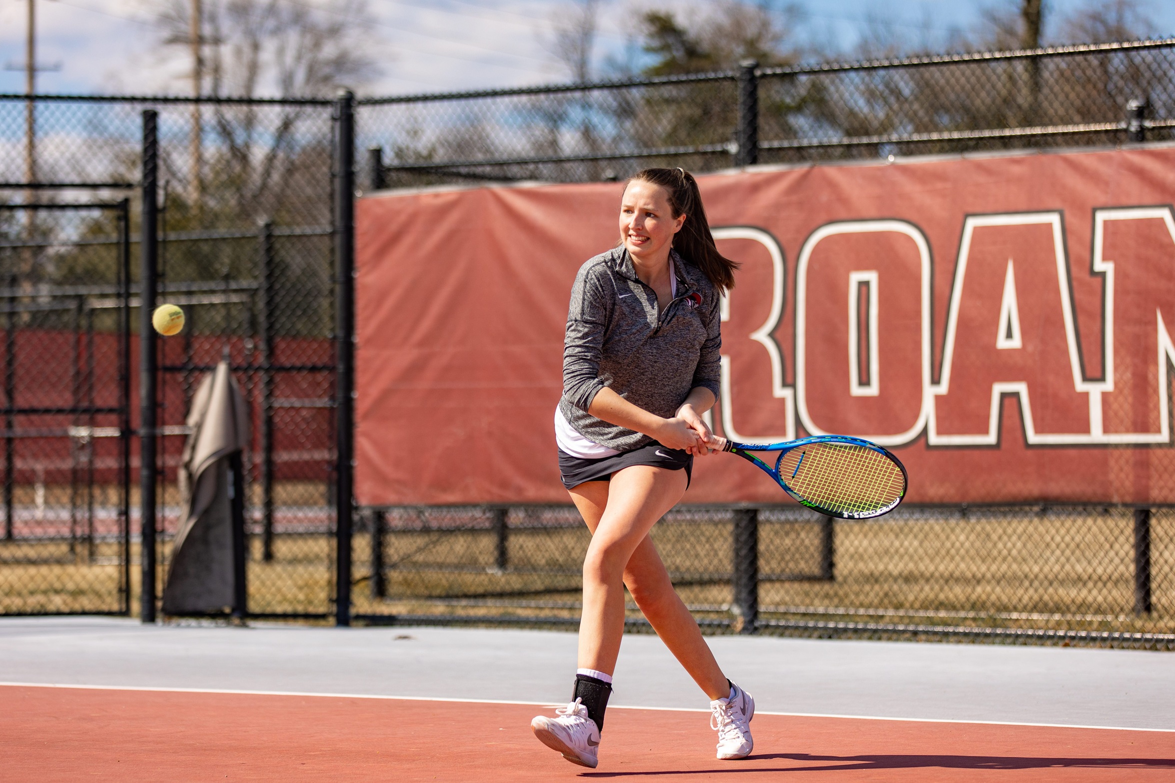 action photo of RC tennis player Sophie Bartholomaus hitting a running backhand