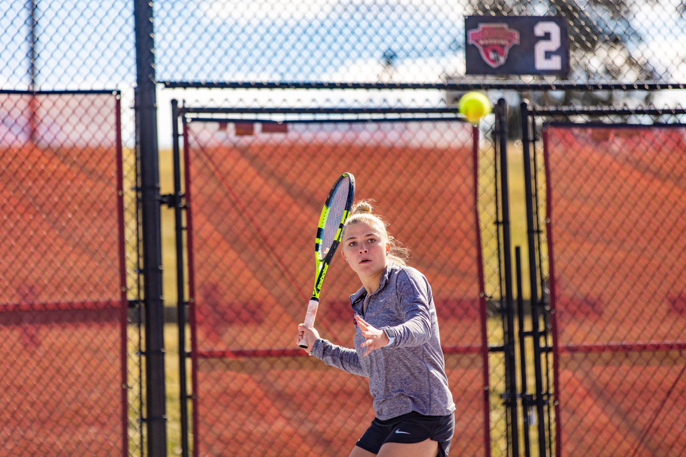 action photo of RC women's tennis player hitting a forehand