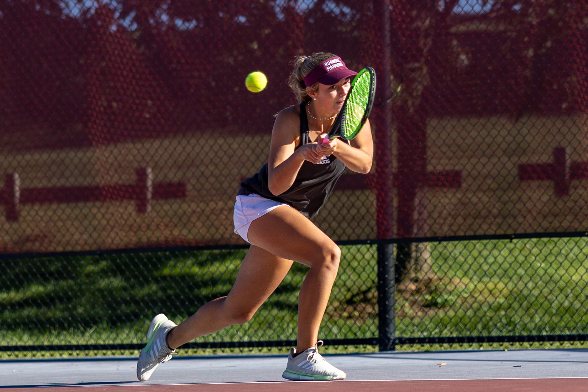 action photo of RC women's tennis player Julia Bassett hitting a backhand