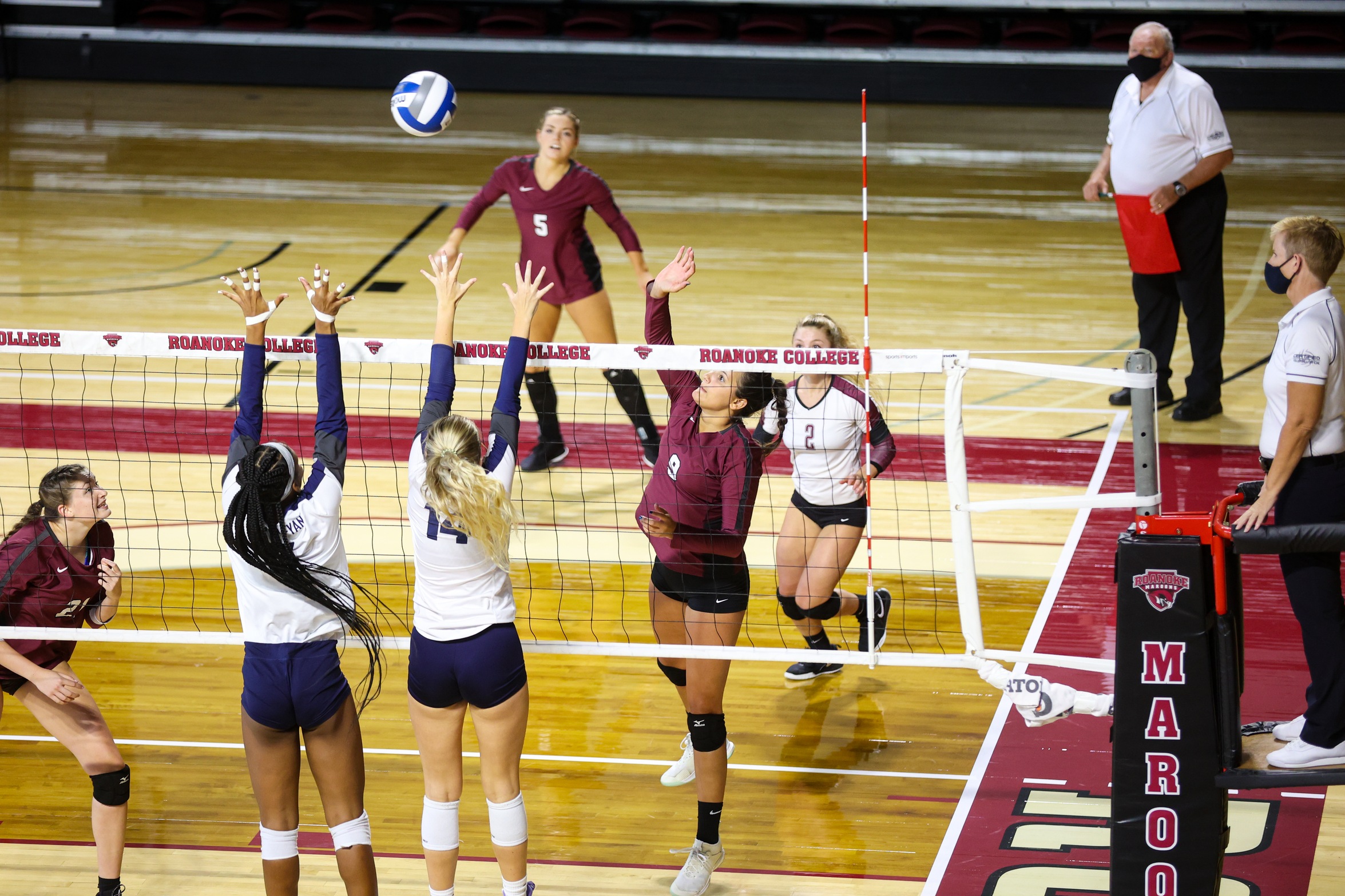 action shot of Angel Ross in volleyball match going against two defenders
