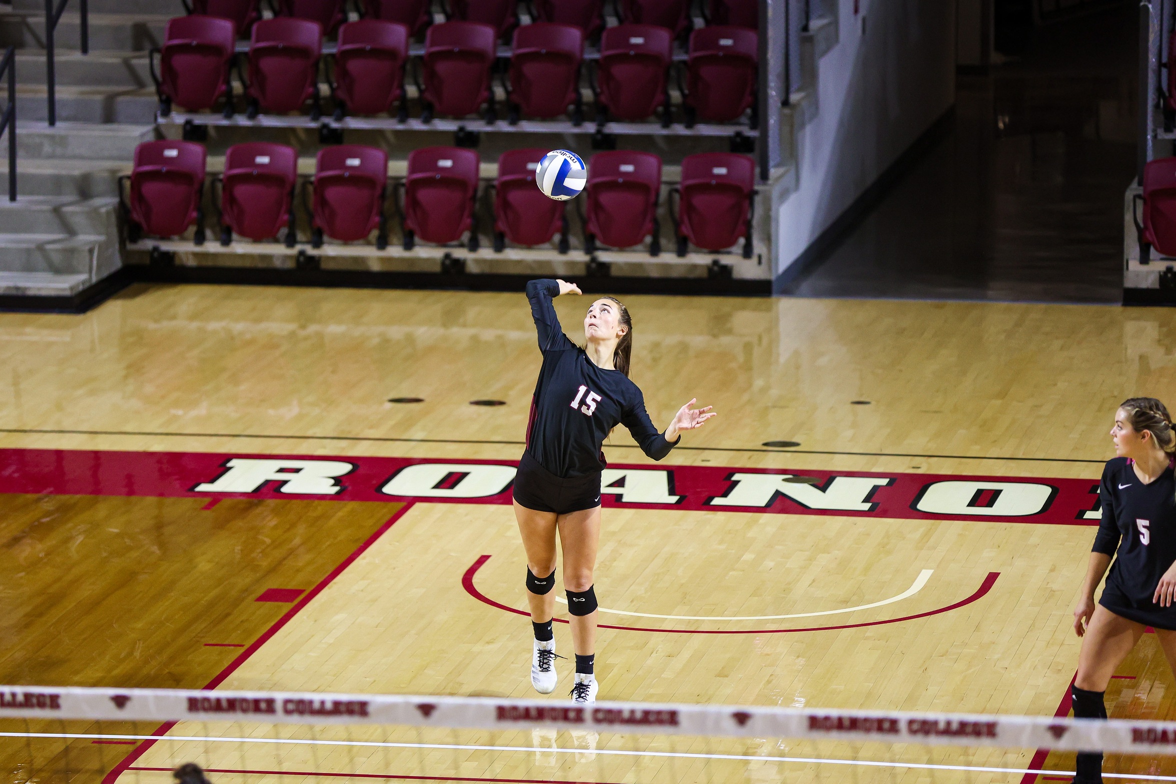 action photo of RC volleyball player Olivia Newman serving